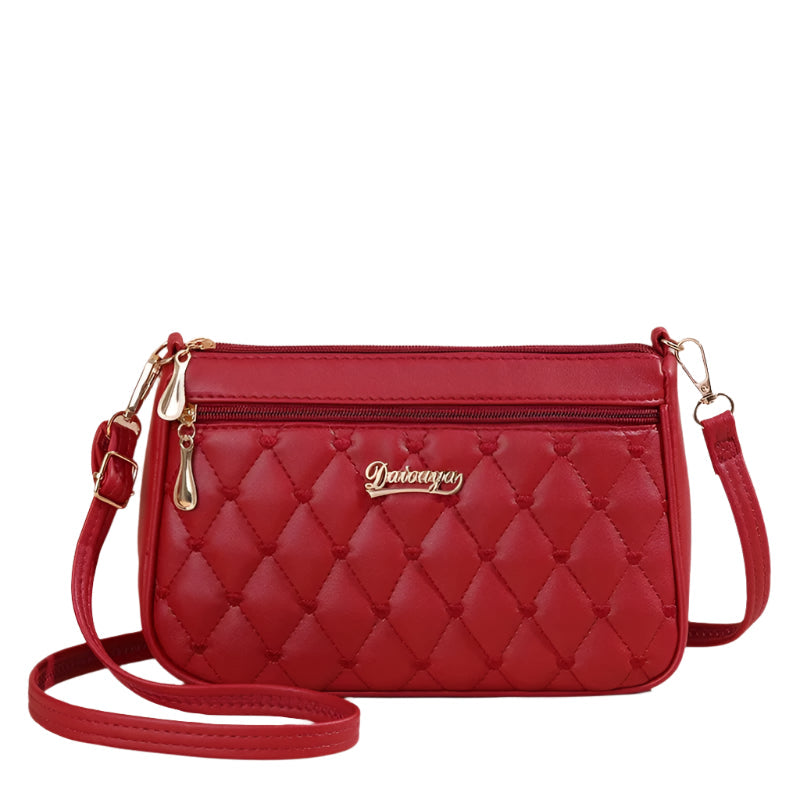 Sidevisning av den broderte crossbody vesken for kvinner, viser slankt og moderne design.