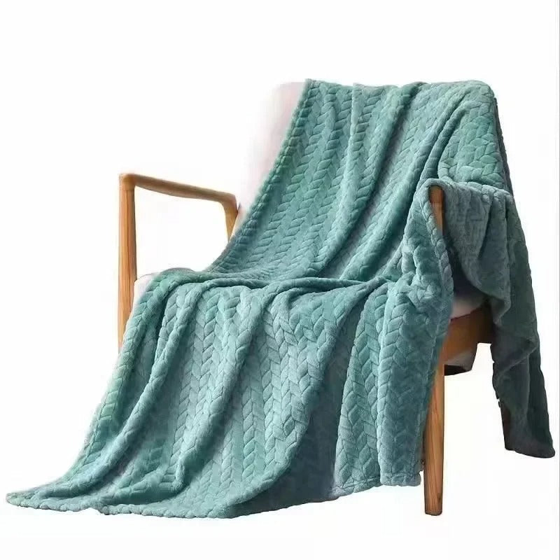 Sammenbrettet korallfløyel pledd på sofa, klar for avslapning, hjemmekos og interiørdekor.