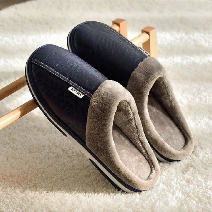 Varmfôrede innetøfler i kunstlær, designet for unisex bruk. Fokus på den sklisikre sålen og slip-on designet.