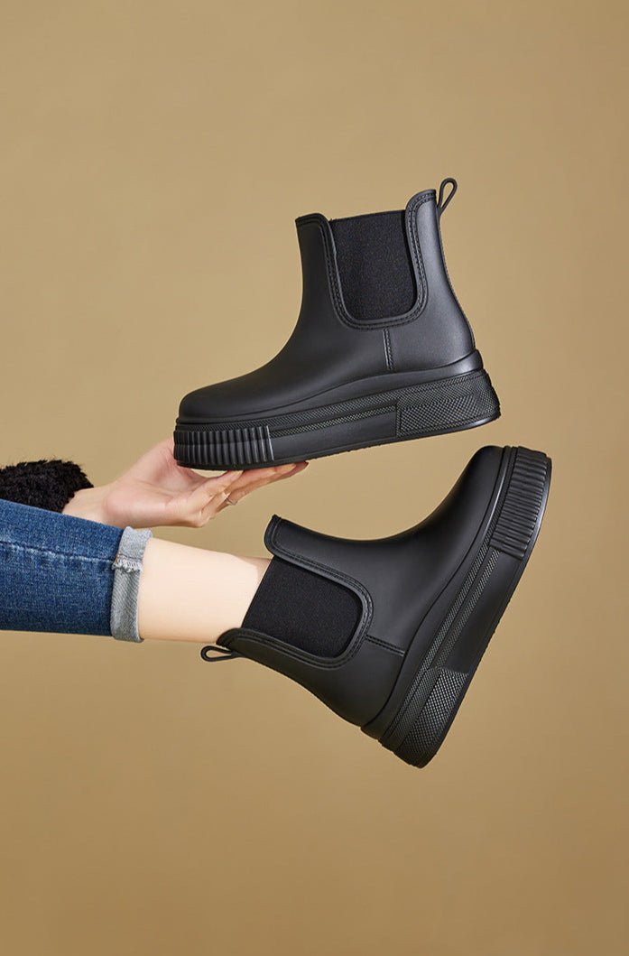 Nærbilde av grønne vanntette Chelsea plattformstøvler. Motedesign med praktiske slip-on funksjoner for damer.