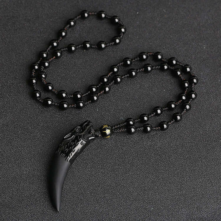 Obsidian anheng: Ulvehalskjede for kvinner, fokus på detaljer og steinens naturlige skjønnhet.