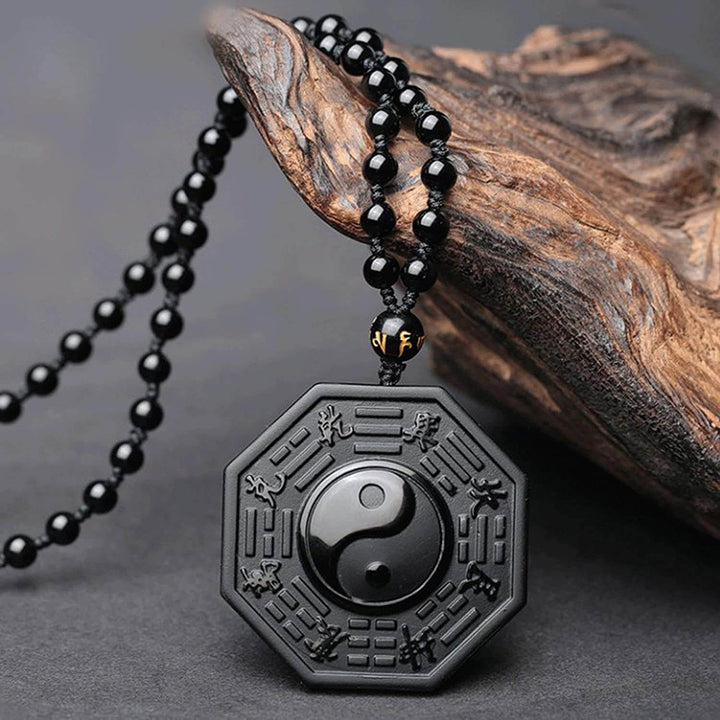 Klassisk yin yang symbol i dyp svart obsidian. Smykke som representerer harmoni og velvære.